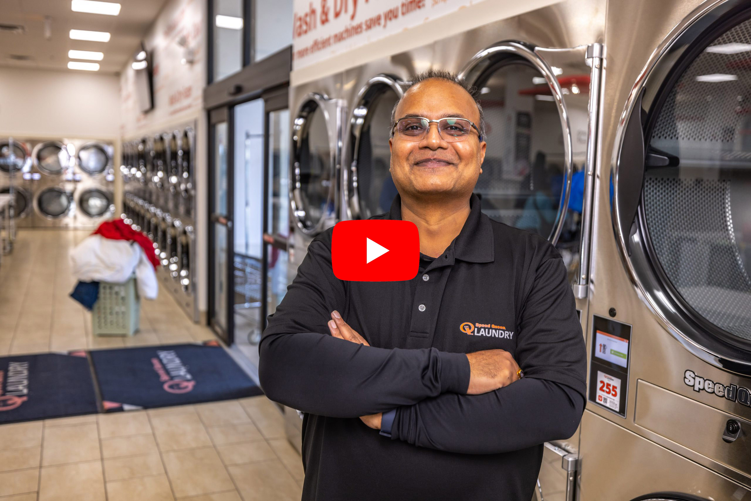 Sanjay standing proudly in his laundromat